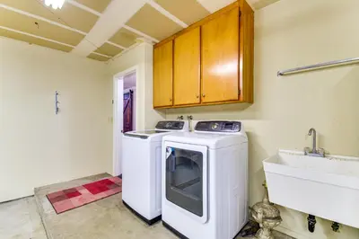 a kitchen with a white washer and a sink at Game Room and Bar Wooded Pine Mountain Lake Retreat in Groveland