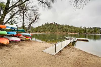 a dock with boats parked on the shore of a lake at Game Room and Bar Wooded Pine Mountain Lake Retreat in Groveland