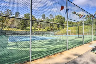 a tennis court with a net on a tennis court at Game Room and Bar Wooded Pine Mountain Lake Retreat in Groveland