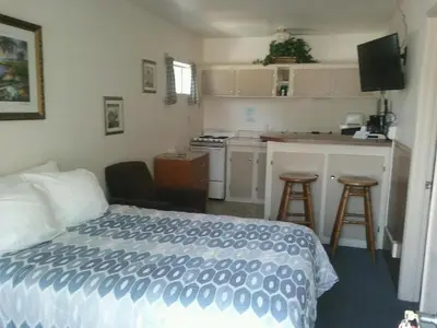 a hotel room with a bed and a kitchen at Bishop Village Motel in Bishop