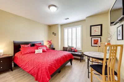 a bedroom with a red bed and a table at Golf, Hike, Explore Apt 9 Mi to Dtwn Fresno! in Fresno