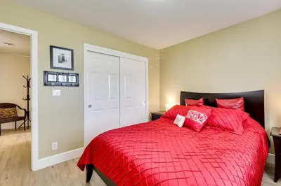 a bedroom with a red bed with red pillows at Golf, Hike, Explore Apt 9 Mi to Dtwn Fresno! in Fresno