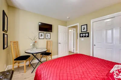 a bedroom with a red bed and a table at Golf, Hike, Explore Apt 9 Mi to Dtwn Fresno! in Fresno