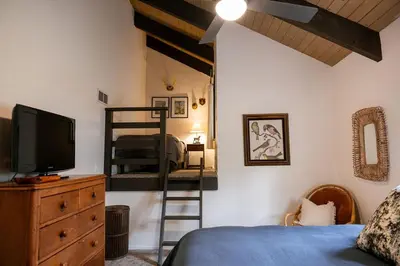 a bedroom with a bunk bed and a television at Tallwood Cabin A Treetop Mountain Retreat in Shaver Lake