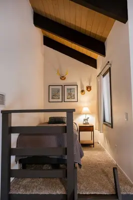 a bedroom with a staircase and a bed in a room at Tallwood Cabin A Treetop Mountain Retreat in Shaver Lake