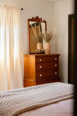 a bedroom with a dresser with a mirror and a bed at Tallwood Cabin A Treetop Mountain Retreat in Shaver Lake
