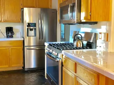 a kitchen with a stove and a stainless steel refrigerator at Large 3 Bedrooms Outdoor Seating in Tahoe Vista