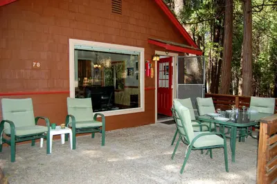 a patio with a table and chairs next to a building at Ox Yoke in Wawona