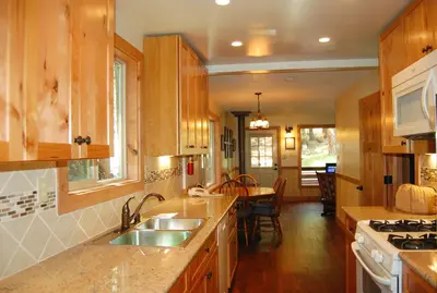 a kitchen with wooden cabinets and a sink and a table at Ox Yoke in Wawona