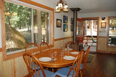 a dining room with a wooden table and chairs at Ox Yoke in Wawona