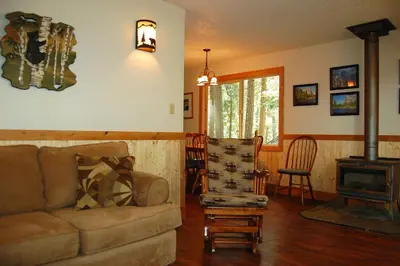 a living room with a couch and a wood stove at Ox Yoke in Wawona