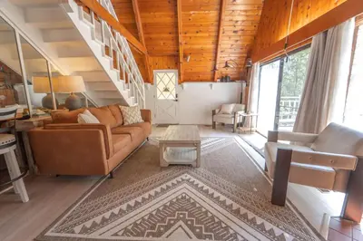 a living room with a couch and a staircase at Sequoia Vintage A-frame River Retreat in Three Rivers