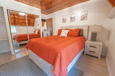 a bedroom with a bed and a mirror at Sequoia Vintage A-frame River Retreat in Three Rivers