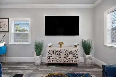 a living room with a tv on a white wall at Walk to UC Davis Medical Center! Duplex with Patio in Sacramento