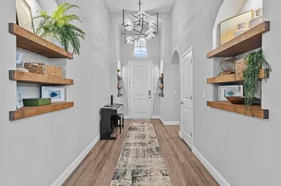 a hallway with white walls and wooden shelves at The Executive Retreat at Westberry in Madera