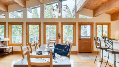 a dining room with a table and chairs and windows at Sleeps 20 2 Homes Near Ski Resort Beach Lake Access Pool Homewood in Tahoma