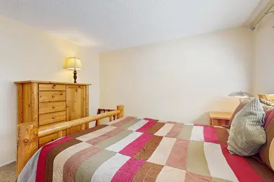 a bedroom with a bed and a dresser with a lamp at Glenwood Getaway in South Lake Tahoe