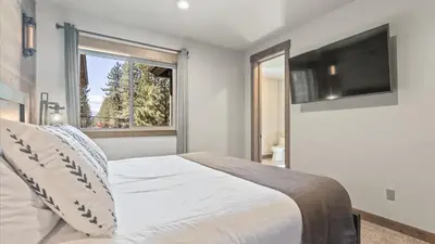 a bedroom with a bed and a tv and a window at South Lake Escape Indoor Pool plus Movie Theater in South Lake Tahoe