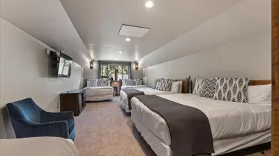 a room with two beds and a couch and a tv at South Lake Escape Indoor Pool plus Movie Theater in South Lake Tahoe