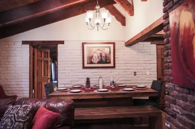 a living room with a wooden table in a brick wall at Pine Ridge Retreat in Stateline