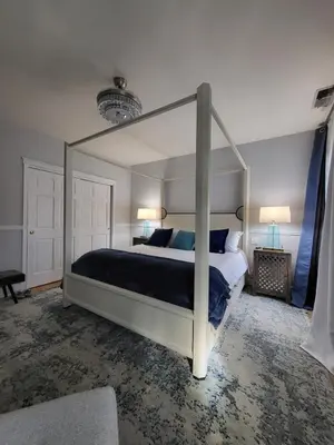 a bedroom with a large canopy bed with blue pillows at Terrace On Main Street in Murphys