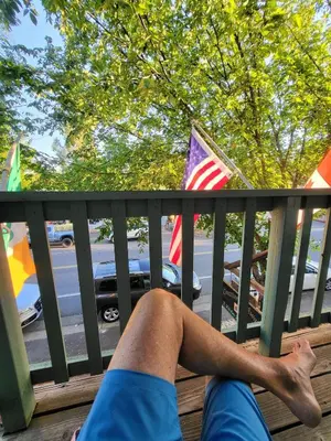 a person laying on a fence with their leg sticking out at Terrace On Main Street in Murphys