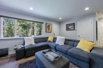 a living room with a blue couch and yellow pillows at Private Woods - Cottage for 4 in South Lake Tahoe