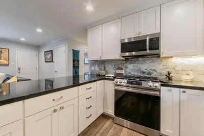 a kitchen with white cabinets and a stove top oven at Private Woods - Cottage for 4 in South Lake Tahoe
