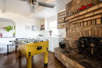 a room with a stone fireplace and a chess table at Grand Wine Country 6BR Retreat Hot Tub & Views in San Martin
