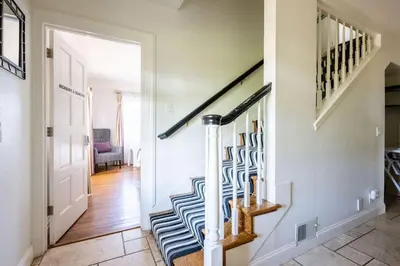 a hallway with a staircase with a blue and white rug at Grand Wine Country 6BR Retreat Hot Tub & Views in San Martin