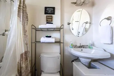 a bathroom with a sink and a toilet and a mirror at Grand Wine Country 6BR Retreat Hot Tub & Views in San Martin