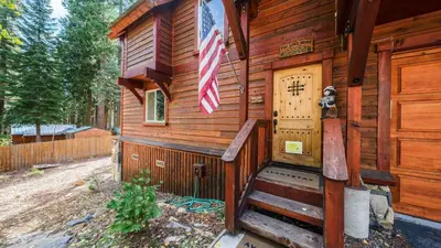 a cabin with an american flag on the door at Outdoor Dining Backyard Trails Nearby Cedar Hollow Retreat by AvantStay in Tahoma