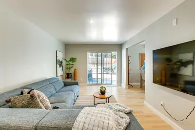 a living room with a blue couch and a tv at Hot Tub and Game Room Luxe Cabin, Day Trip to Tahoe in Pollock Pines