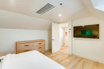 a bedroom with a bed and a tv on a wall at Hot Tub and Game Room Luxe Cabin, Day Trip to Tahoe in Pollock Pines