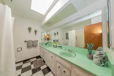 a bathroom with a sink and a large mirror at Sierra View Retreat with Newly Installed Hot tub! in Oakhurst