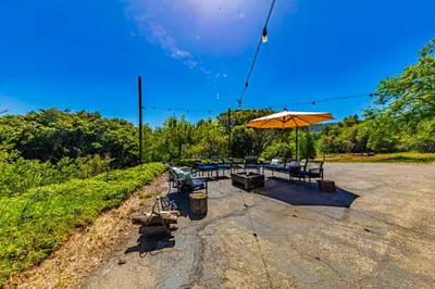 a picnic table with an umbrella and chairs at Sierra View Retreat with Newly Installed Hot tub! in Oakhurst