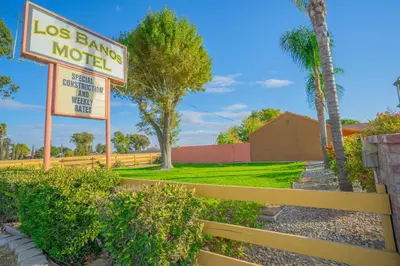 a sign for a las bandana motel next to a fence at Los Banos Motel in Los Banos