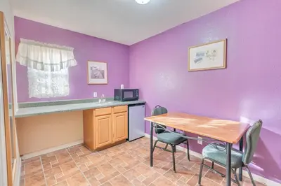 a kitchen with purple walls and a table and chairs at Los Banos Motel in Los Banos