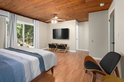 a bedroom with a bed and a flat screen tv at WoodUStau in Coarsegold