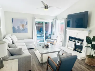 a living room with white furniture and a fireplace at Contemporary, newly renovated and great location in Fresno