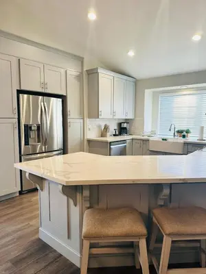 a kitchen with white cabinets and a large island at Contemporary, newly renovated and great location in Fresno