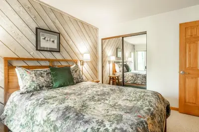 a bedroom with a large bed and a mirror at 3 Bedrooms + Loft townhome in Snowcreek Phase 3, Private Pool Table Sleeps 6 Guests, Dog Friendly in Mammoth Lakes