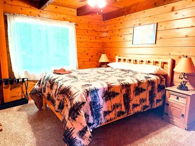 a bedroom with a bed and a window in a cabin at Rustic and Scenic in Cold Springs