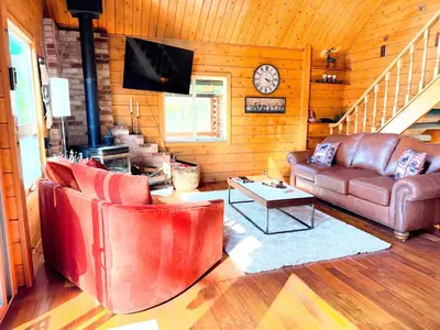a living room with leather furniture and a tv at Rustic and Scenic in Cold Springs