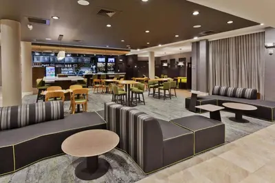 a hotel lobby with tables and chairs and a restaurant at Courtyard by Marriott Fresno Downtown in Fresno