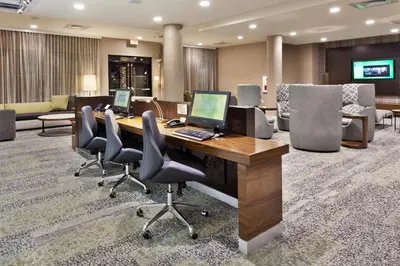 a conference room with a desk with a laptop and chairs at Courtyard by Marriott Fresno Downtown in Fresno