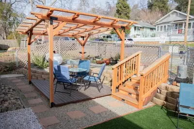a wooden pergola with a table and chairs on a patio at Sleeps 2 Private Entrance, Spa Tub, Near Casino in Tuolumne