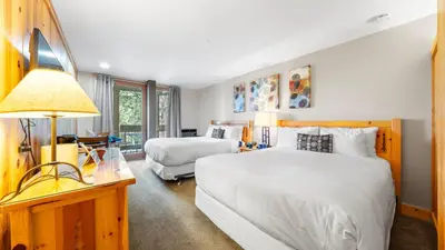 a bedroom with two beds and a desk with a lamp at Cozy Northstar Village Escape w Forest Views Easy Lift Access Alpineglow Vista by AvantStay in Truckee