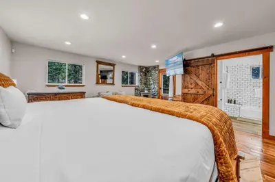 a bedroom with a large white bed and a television at Kings Beach Retreat Hot Tub & Game Loft in Kings Beach
