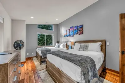 a bedroom with two beds and a desk and a window at Kings Beach Retreat Hot Tub & Game Loft in Kings Beach
